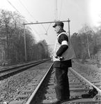 171737 Afbeelding van een veiligheidsman van de N.S. met signaalhoorn en geel vest op de spoorlijn ter hoogte van ...